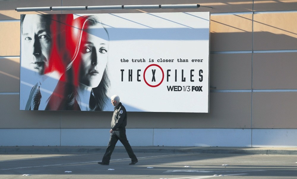 A security guard walks past a billboard for u2018The X Files' on the lot of 20th Century Fox in Century City, Califorinia.