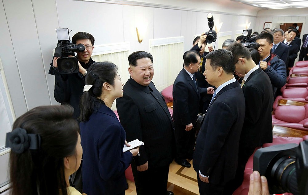 This picture from North Korea's official Korean Central News Agency (KCNA) taken on March 27, 2018 and released on March 28, 2018 shows North Korean leader Kim Jong Un (4th L) speaking with Chinese officials (R) inside a special train in an undisclosed location.
