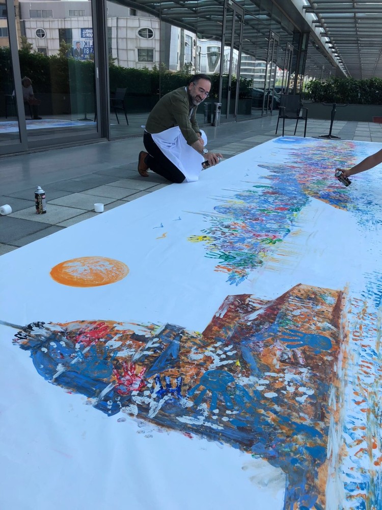 Students used their handprints to color a giant painting of the Istanbul skyline.