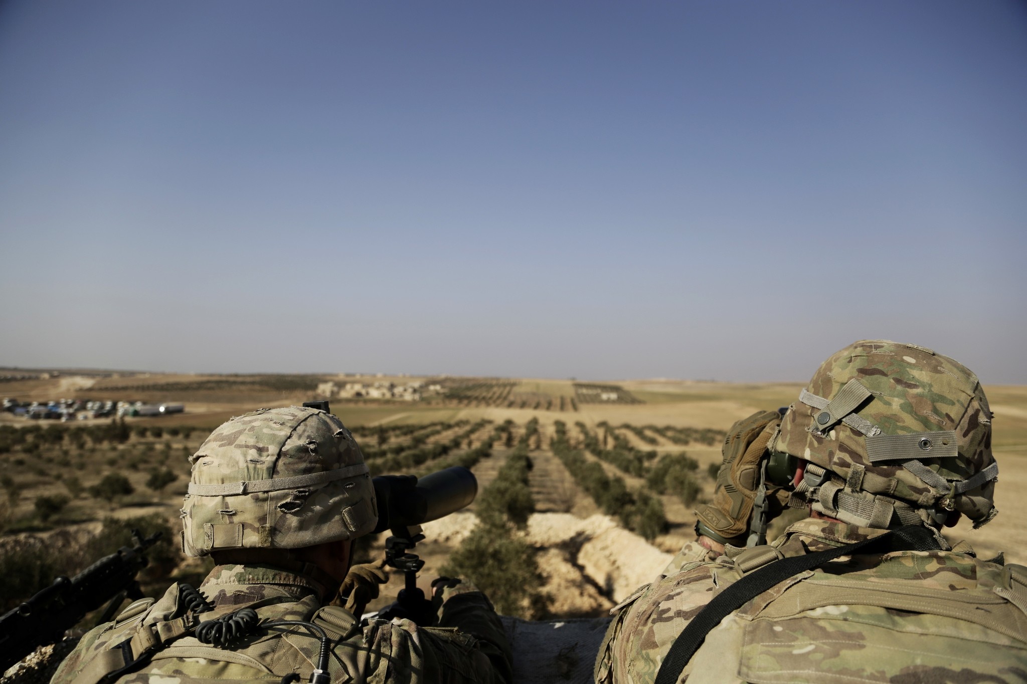 This photo shows American troops looking  toward the border with Turkey from a small outpost near the town of Manbij, northern Syria (AP File Photo)
