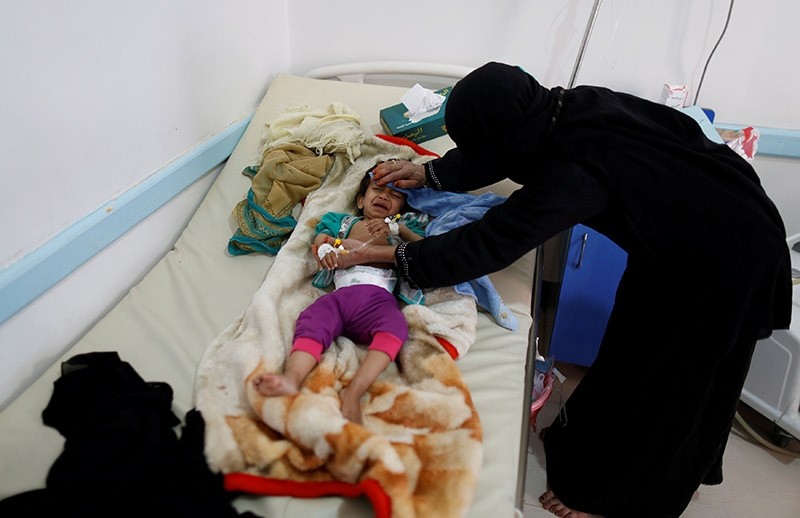 A woman helps her son as he lies on a bed at a cholera treatment center in Sanaa, Yemen June 6, 2017 (Reuters Photo)