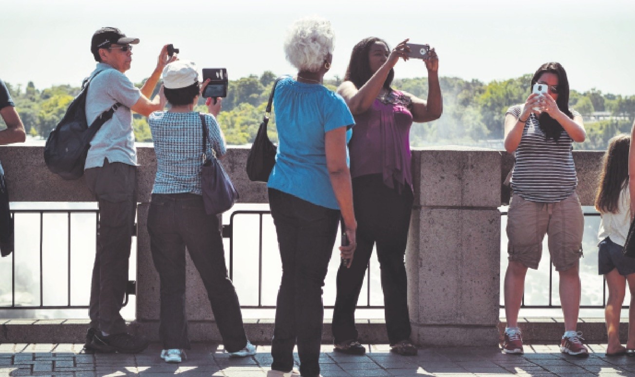 Tourists take photos of the surrounding, ignoring the human connection around them.
