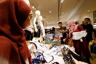Customers hold clothes during late night Ramadan shopping at Gandaria Mall in Jakarta, Indonesia.