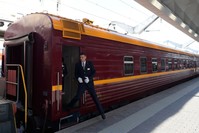 A train conductor steps down from a car of the first tourist train passing through Russia's Arctic regions to Norway as it prepares to leave Saint Petersburg for a 11-day trip with 91 passengers on board, June 5, 2019. (AFP Photo)