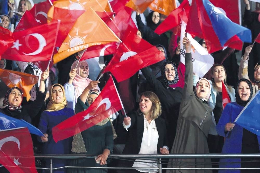Supporters of President Erdou011fan shout slogans and wave flags as he arrives at a meeting to announce his ruling AK Party's manifesto for next month's elections, Ankara, May 24.