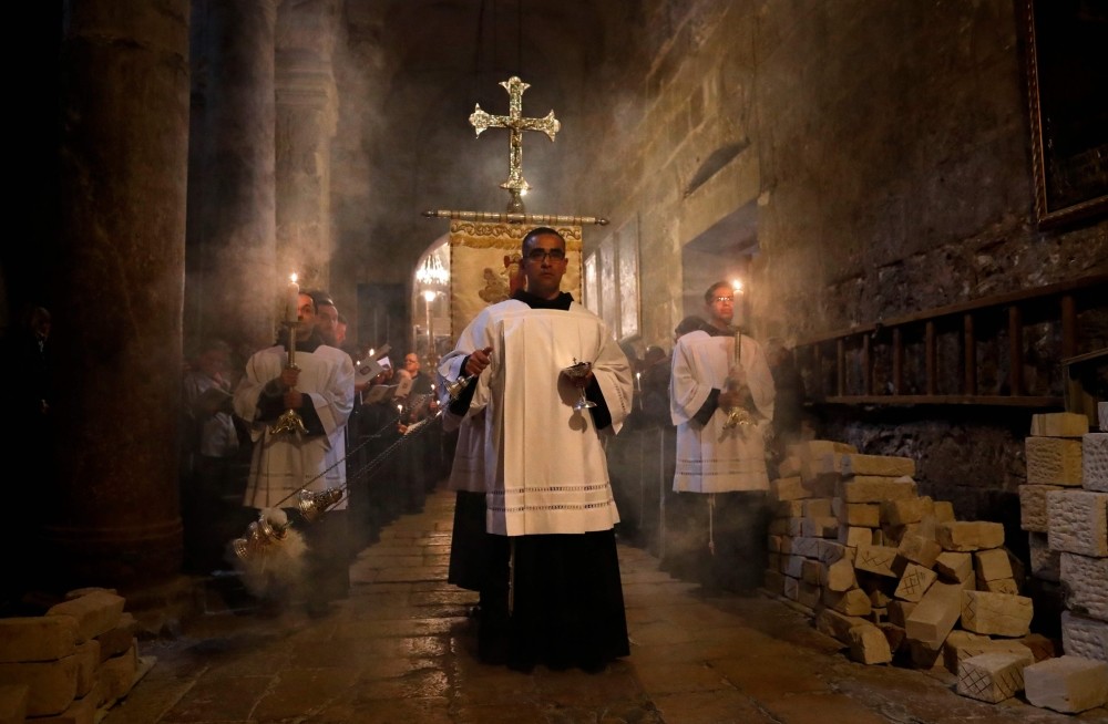 Franciscan friars pray during the Lenten procession inside the Church of the Holy Sepulchre in the Old City of Jerusalem.