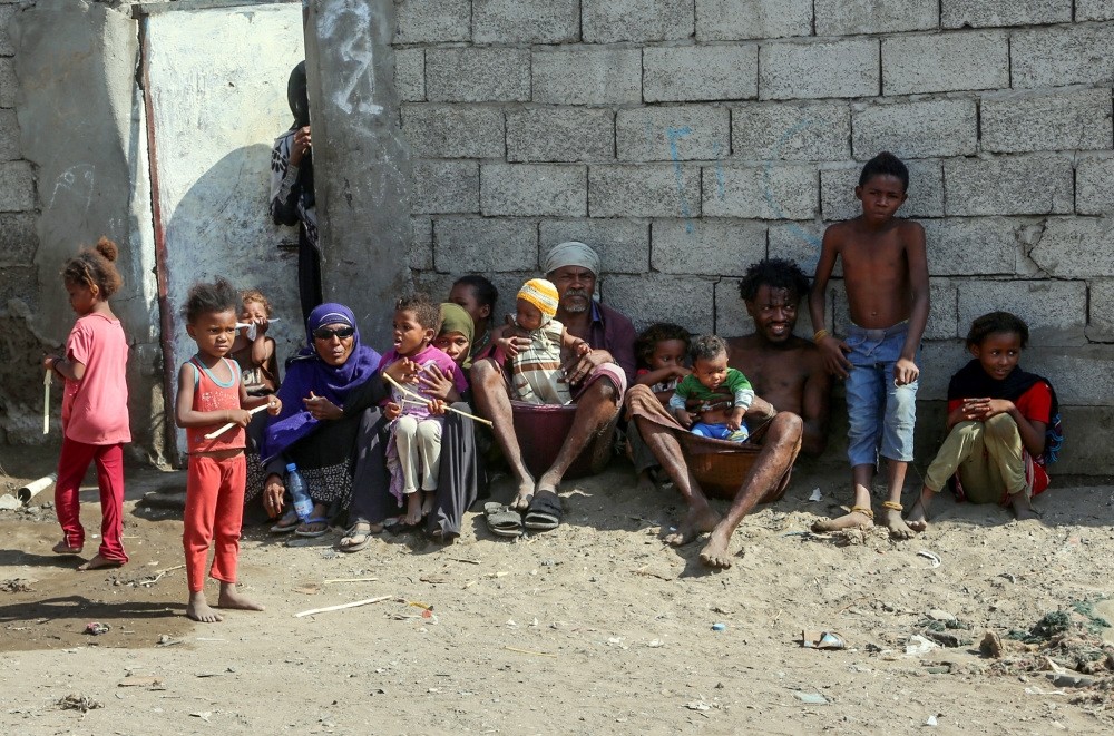 Members of a poor Yemeni family sit together next to a wall in the embattled Red Sea port city of Hodeidah, Jan. 11, 2019.