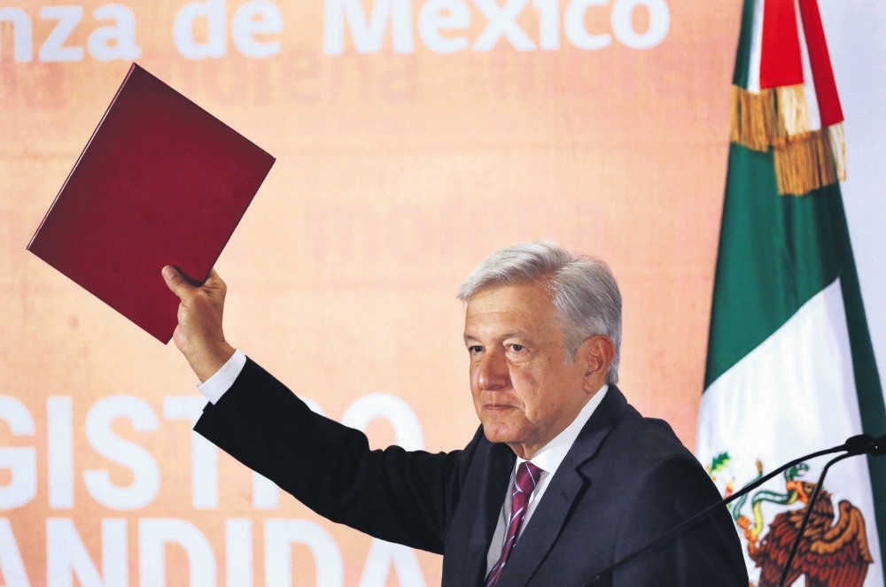 Mexico's President-elect Andres Manuel Lopez Obrador, more widely known as Amlo, holds up his candidacy application for the July 2018 elections.