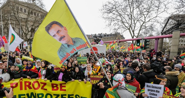 PKK followers carry a flag with a picture of terrorist group’s leader and other banned posters and flags in Frankfurt, Germany. (EPA Photo)
