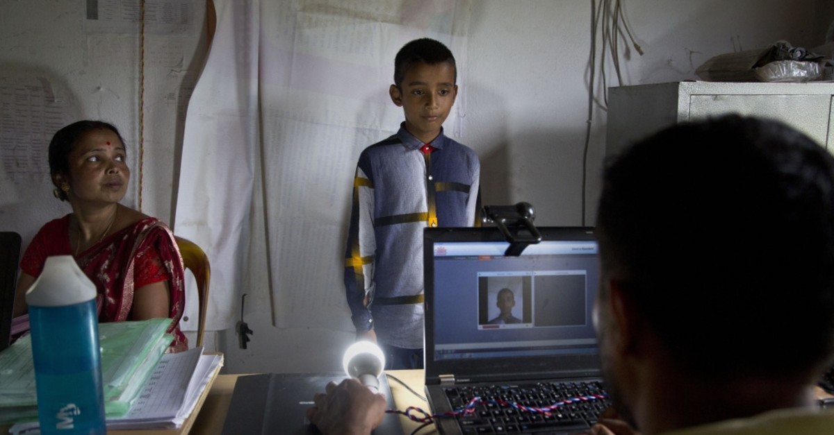 A National Register of Citizens (NRC) officer takes a photograph of a boy at an NRC center, Gauhati, Aug. 30, 2019.