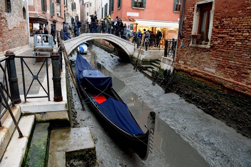 A gondola is seen tied up in Venice, near the Rialto bridge, on January 31, 2018, as exceptionally low tides have drained the lagoon city. (AFP Photo)