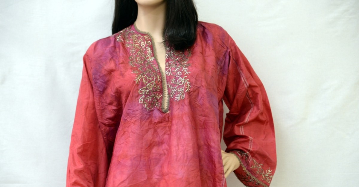 The shirt is made of red silk featuring hand embroidery.