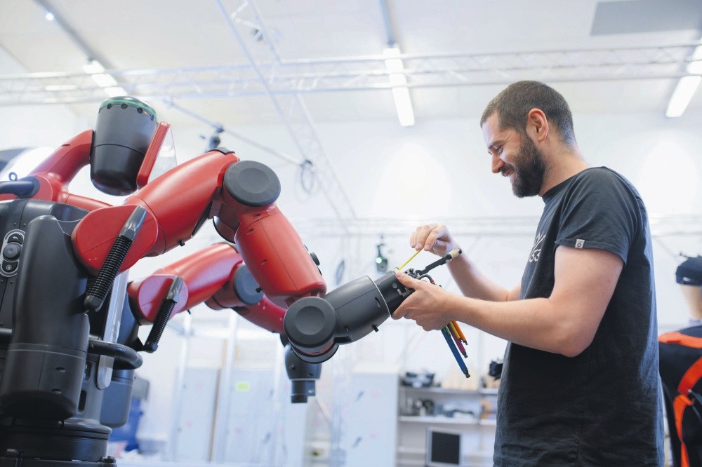 A technician works on a robotic arm. Soon, new jobs will emerge to meet the different needs brought on by technological advances.