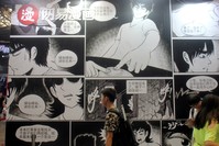 People walk past a booth of NetEase Comics at the China International Cartoon and Game Expo in Shanghai.