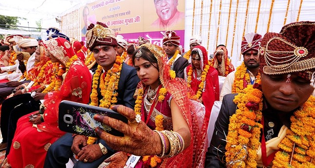 An Indian bride takes a selfie with her husband during a mass marriage ceremony on the occasion of the Akshaya Tritiya festival Bhopal, India, 29 April 2017 (EPA Photo)