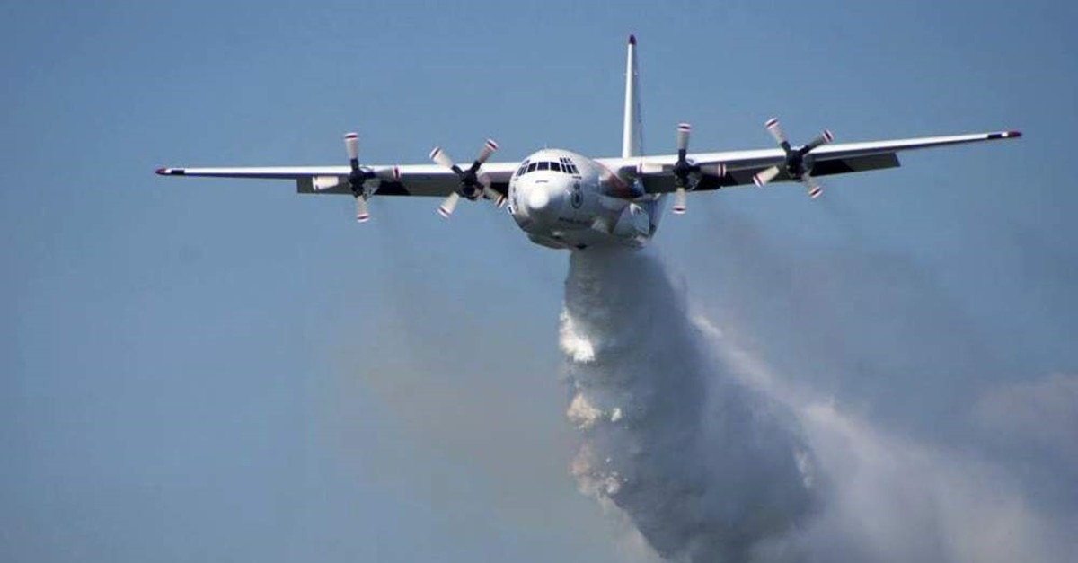 In this undated photo released from the Rural Fire Service, a C-130 Hercules plane called ,Thor, drops water during a flight in Australia. (RFS via AP)