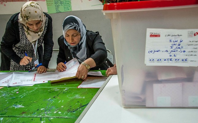 Polling officers count votes at a polling station in Tunis, Tunisia