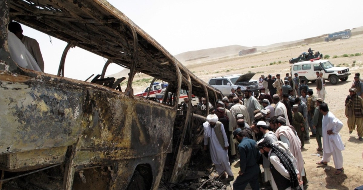Afghan security officials survey the scene of a transport accident in Maiwand district of Helman province, Afghanistan, 26 April 2013 (EPA File Photo)