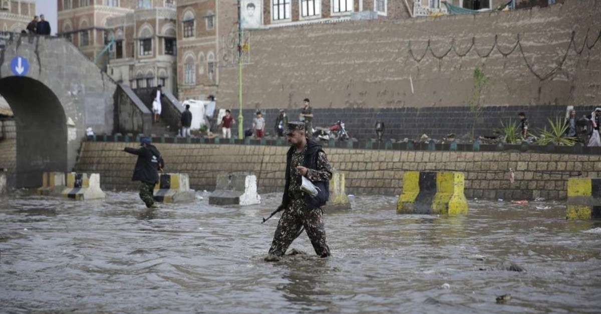 A Houthi militant guards a flooded street leading to a protest against the U.S. airstrike in Iraq that killed Iraqi militia commander Abu Mahdi al-Muhandis and Iranian Gen. Qassem Soleimani, in Sanaa, Yemen, Jan. 6, 2020. (AP Photo)