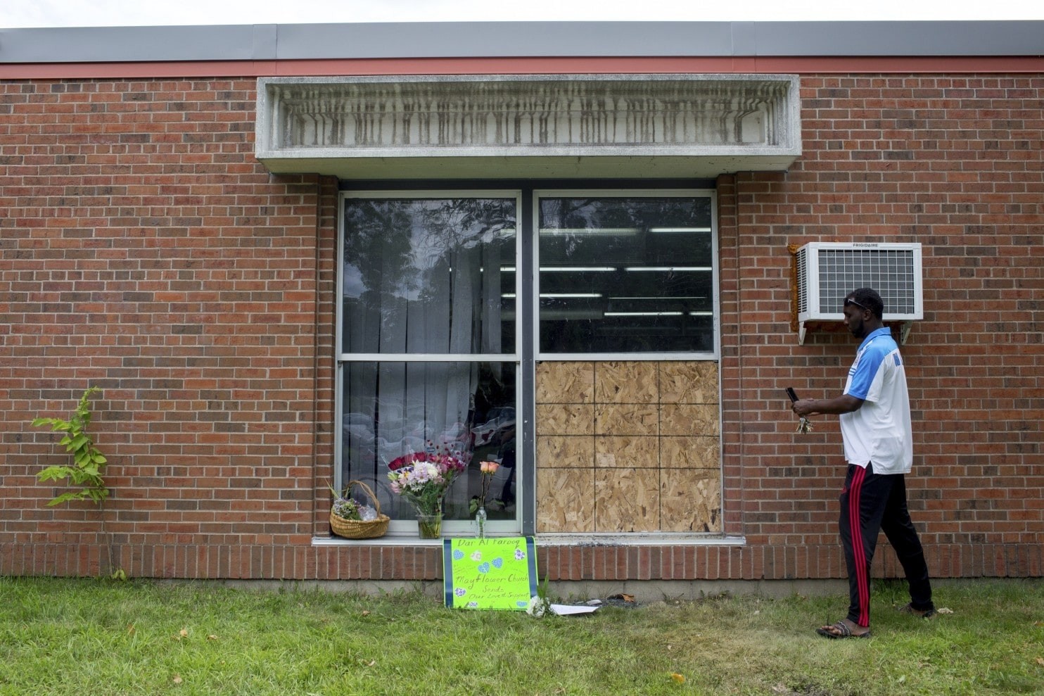 Abdul Mohamed photographs the damage outside of the Dar Al Farooq Islamic Center in Bloomington, Minnesota, Sunday, Aug. 6, 2017. (AP Photo)