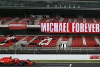 Ferrari driver Sebastian Vettel of Germany drives by a tribute-banner in honor of former German driver Michael Schumacher during a Formula One pre-season testing session in Barcelona.