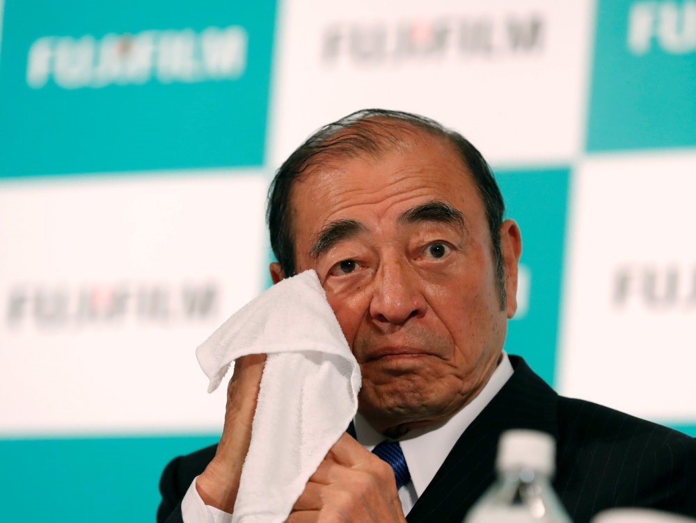 Fujifilm Holding Chief Executive Officer Shigetaka Komori wipes his face at a news conference in Tokyo.