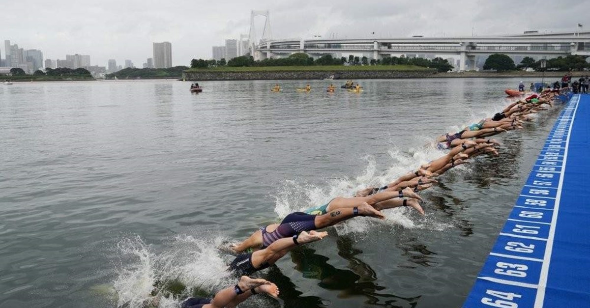 Athletes dive into the water during a triathlon test event at Odaiba Marine Park, a venue for marathon swimming and triathlon at the Tokyo 2020 Olympics, in Tokyo, Aug. 15, 2019. (AP Photo)
