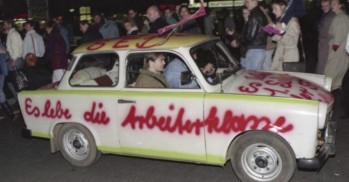 In this Nov. 11, 1989, file photo a Trabant car, made in East Germany, with a graffiti slogan 'Es lebe die Arbeiterklasse' (Shall the laboring classes live on) is pictured driving in West Berlin (AP File Photo)