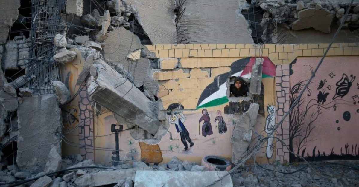 A Palestinian boy peaks through a hole in the wall of a school destroyed by Israeli airstrikes, May 7, 2019. (AFP Photo)