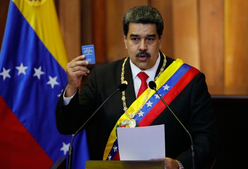 In this Jan. 10, 2019, file photo, Venezuela's President Nicolas Maduro holds up a small copy of the constitution as he speaks during his swearing-in ceremony at the Supreme Court in Caracas (AP Photo)