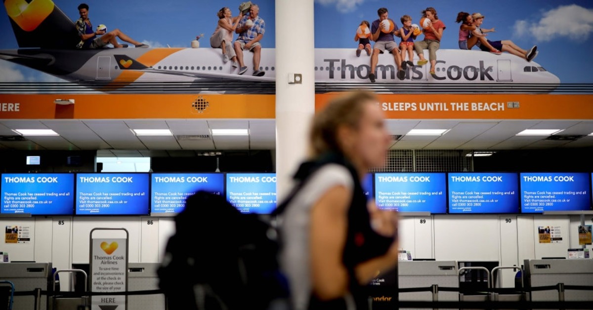 Passengers walk past the closed Thomas Cook check-in desks at the South Terminal of London Gatwick Airport in Crawley, south of London, Sept. 23, 2019,