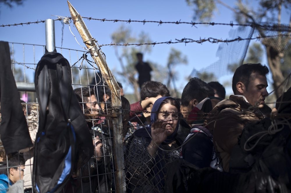 People wait in line to enter the migrant and refugee registration camp in Moria, on the island of Lesbos, Nov. 4, 2015.