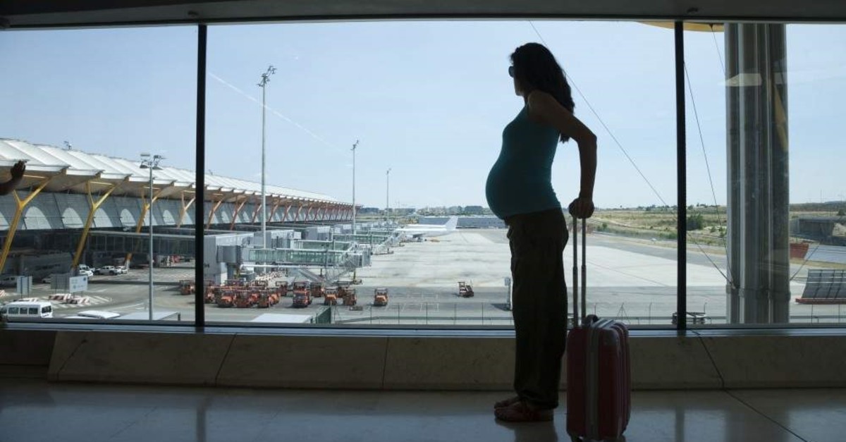 A pregnant woman waits at an airport. (iStock)