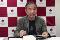 Japanese novelist Haruki Murakami autographs his novel ,Killing Commendatore, during a press conference at Waseda University.