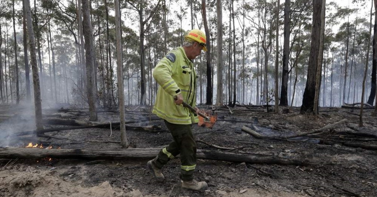 A worker patrols a controlled fire as they work on building a containment line for a wildfire near Bodalla, Jan. 12, 2020. (AP Photo)