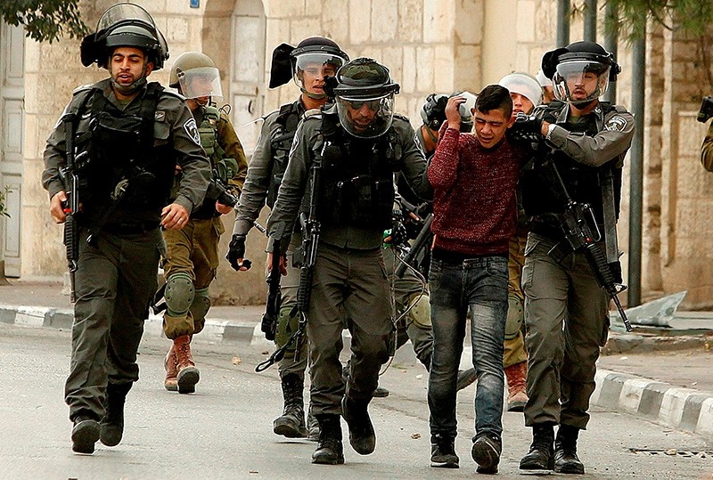 Israeli soldiers detain a Palestinian boy during a demonstration in the occupied West Bank city of Bethlehem on Dec. 22, 2017. (Getty Images)