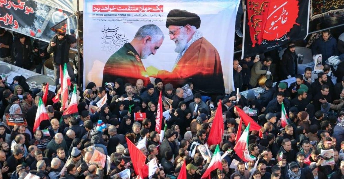 Iranian mourners carry a picture of Iran's Supreme Leader Ayatollah Ali Khamenei (R) granting the Order of Zolfaghar, the highest military honour of Iran, to General Qasem Soleimani, during the latter's funeral procession, Tehran, Jan. 6, 2020. (AFP PHOTO)