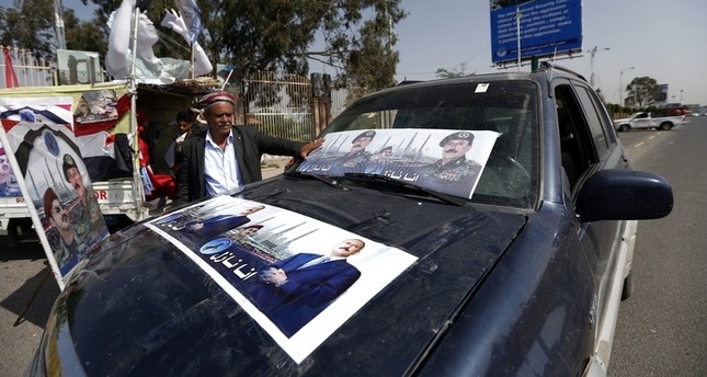 مواطن يمني يرفع صور الرئيس المخلوع الفرنسية