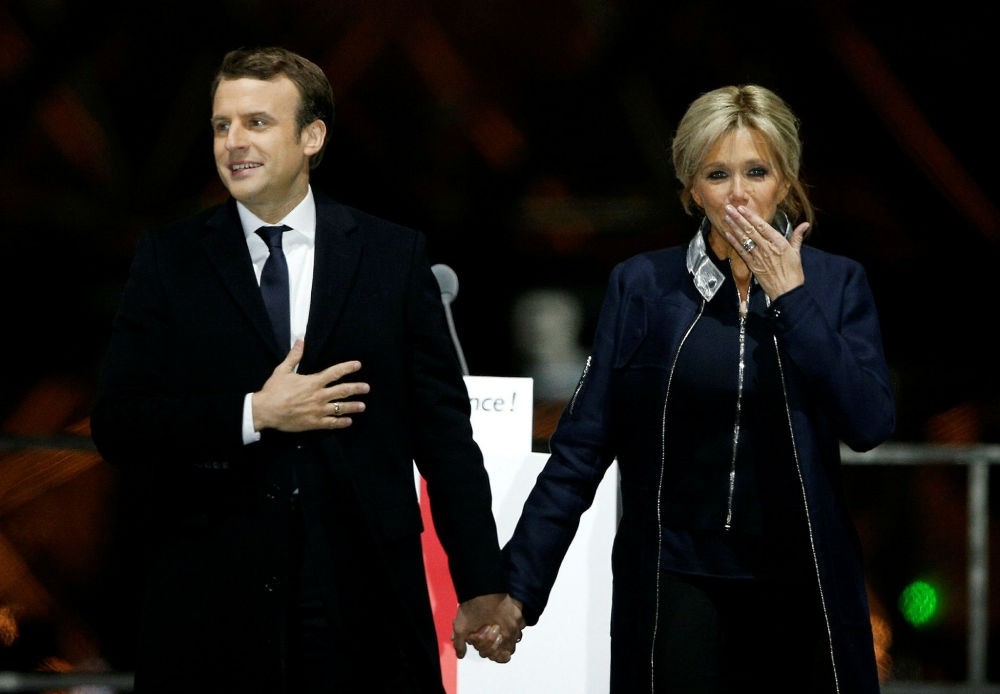 French President-elect Emmanuel Macron holds hands with his wife Brigitte during a victory celebration outside the Louvre museum in Paris, France, May 7.