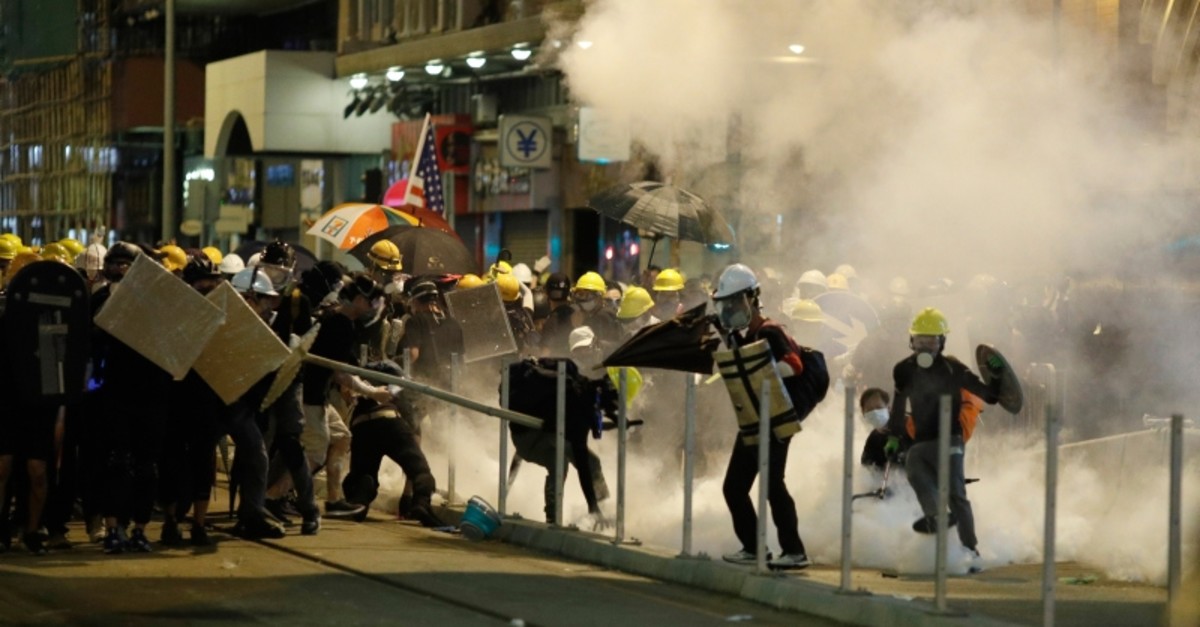 Protesters react to teargas as they confront riot police officers in Hong Kong on Sunday, July 21, 2019. (AP Photo)