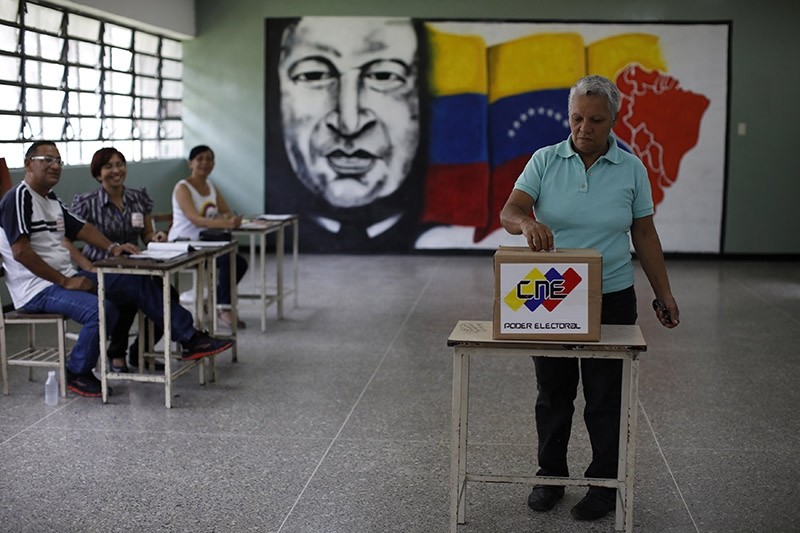 Electoral officials watch as a woman casts her vote at a polling station during the Constituent Assembly election in Caracas, Venezuela, July 30, 2017. (Reuters Photo)