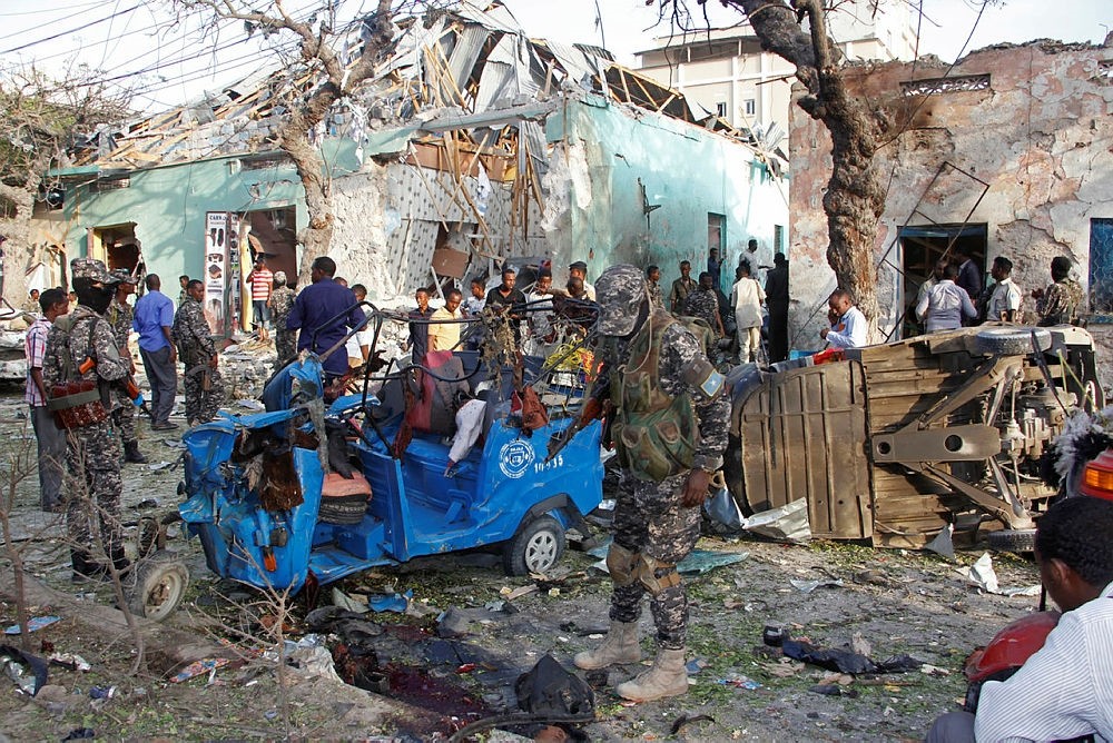 Somalis stand outside a destroyed building after a car bomb in Mogadishu, Somalia, March 22, 2018. (AP Photo)