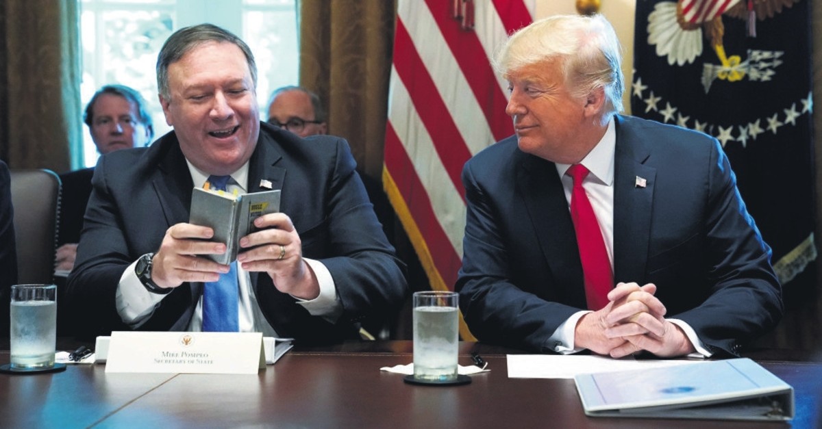 U.S. Secretary of State Mike Pompeo (L) and U.S. President Donald Trump look at Pompeo's West Point cadet handbook from his time at the U.S. Military Academy in the 1980s at the White House in Washington, Aug. 16, 2018.