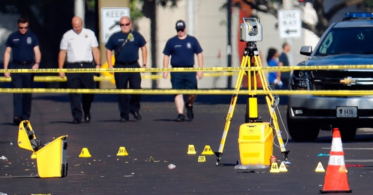 Evidence markers rest on the street at the scene of a mass shooting Sunday, Aug. 4, 2019, in Dayton, Ohio. 