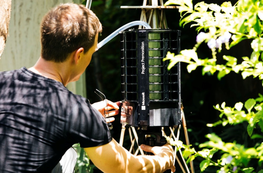 Researcher Ethan Jackson places the Project Premonition mosquito trap in the wild.