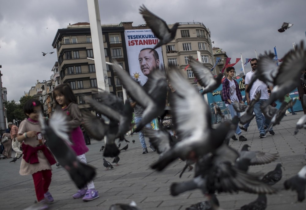 Pedestrians walk in front of a poster of President Recep Tayyip Erdou011fan, which reads ,Thank You, Istanbul,, two days after the June 24 presidential vote in 2018, in Taksim Square, Istanbul.