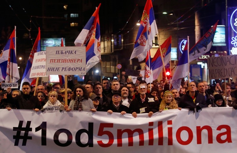 People hold a banner that reads: '#1out of 5 million' during a protest against President Aleksandar Vucic in Belgrade, Serbia, Saturday, Dec. 29, 2018. (AP Photo)
