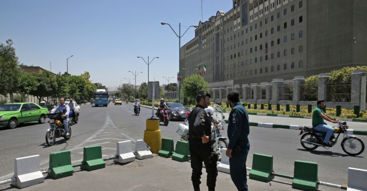 Police officers stand guard as vehicles drive past Iran's parliament building in Tehran, Iran, Thursday, May 8, 2017 (AP File Photo)