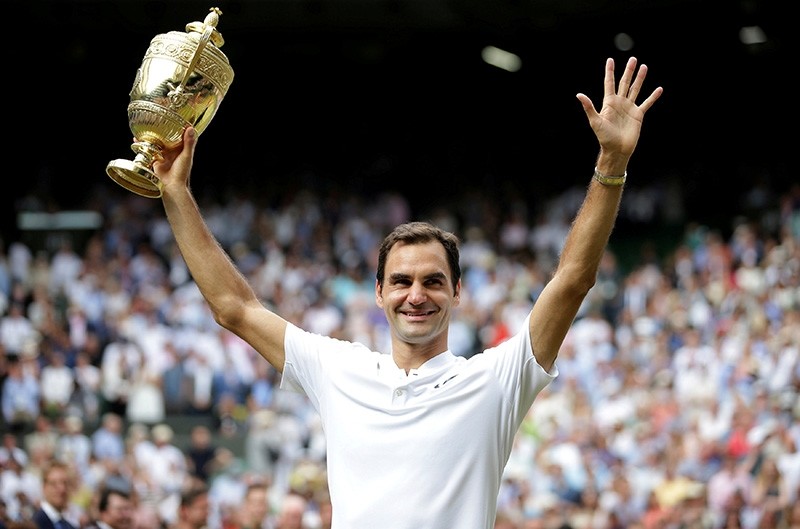 Switzerlandu2019s Roger Federer poses with the trophy as he celebrates winning the 2017 Wimbledon final against Croatiau2019s Marin Cilic. (Reuters Photo)