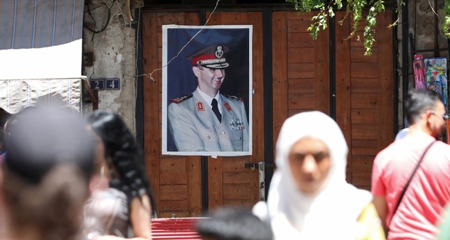 صورة رأس النظام السوري معلقة على أحد المحلات في دمشق الفرنسية
